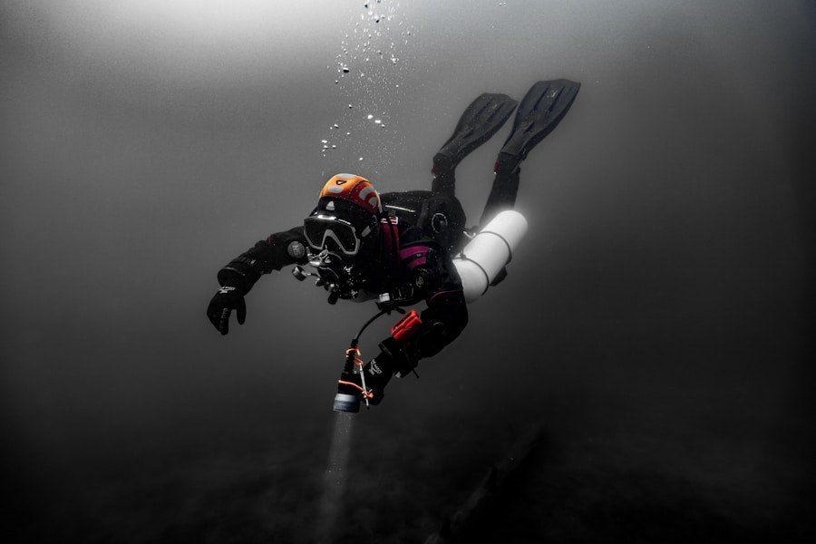 Divers in wetsuits entering choppy dark water at a pier